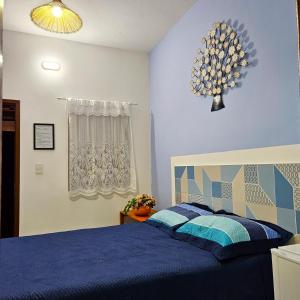 库穆鲁沙蒂巴Villa Mar a Vista - Suite Alamanda的一间卧室配有一张带蓝色棉被的床