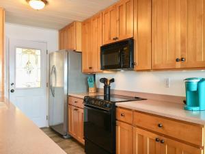 Saratoga ShoresBreezy Point Hideout BY Betterstay的厨房配有木制橱柜和黑炉。