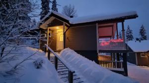 耶姆赛Villa Magnolia 1 Himos的夜晚雪中的一个小屋