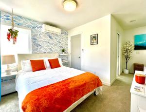 西雅图Capitol Luxe Two BY Betterstay的一间卧室配有一张带橙色毯子的大床