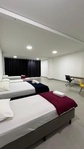 博尼图Flat Central的一间带三张床和钢琴的卧室