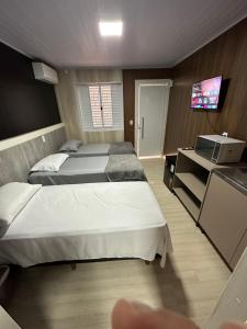沙佩科Loft Lux 5的一间卧室配有两张床和电视。