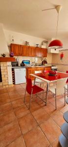 塞图巴尔Casa da Ti Bia的一间厨房,里面配有桌子和红色椅子