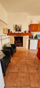 塞图巴尔Casa da Ti Bia的客厅设有石头壁炉,厨房设有