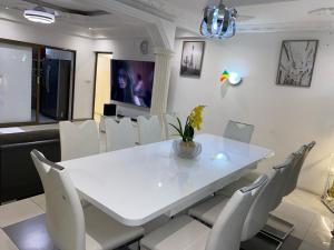 布拉柴维尔Villa Palmeraie的白色的用餐室配有白色的桌椅