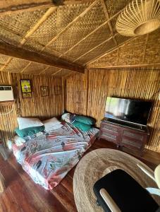 UbayJoseph Agricultural Farm的一间卧室配有一张床,并在一间客房内配有电视。