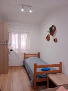 贝尔格莱德Visoki Vrh Apartman的一间卧室配有一张床、一张桌子和一个窗户。