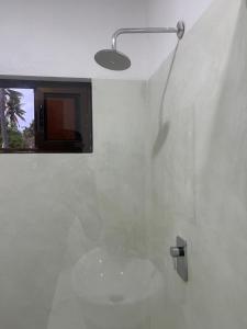 伊尼扬巴内CosyBe Villas的白色浴室设有淋浴和窗户