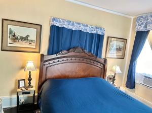 谢尔比维尔Belmont Inn的一间卧室配有蓝色的床和蓝色窗帘