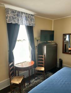 谢尔比维尔Belmont Inn的一间卧室配有一张床、一张桌子和一个窗户。