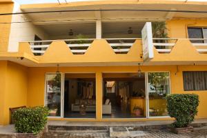 巴拉德纳维达Hotel San Lorenzo的黄色的房屋设有门廊和阳台