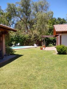卢汉德库约Posada del. Huerto的一个带游泳池和房子的庭院