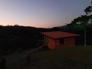 乌鲁比西Recanto do Ipê (cabana 02)的小屋的背景是日落