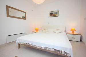 科洛塞普Apartments by the sea Kolocep, Elafiti - 2182的白色卧室配有白色的床和两盏灯。