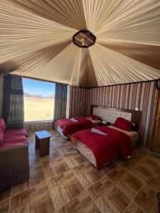 瓦迪拉姆Karam Wadi Rum camp的一间卧室配有两张床和一张沙发。