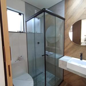 巴拉那州蓬塔尔Ap 01 apartamento Beira mar的一间带玻璃淋浴和水槽的浴室