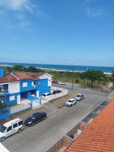 巴拉那州蓬塔尔Ap 01 apartamento Beira mar的一条在蓝色建筑前停有车辆的街道