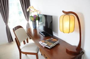 香港文化旅館 - 翠雅山房的一张桌子,上面有一台电视和花瓶