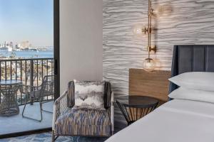 圣地亚哥圣地亚哥喜来登海滨酒店的一间带一张床和一把椅子的卧室以及一个阳台