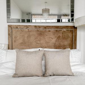 布罗姆利Preciousluxurysuit的一张带两个枕头的床和木制床头板