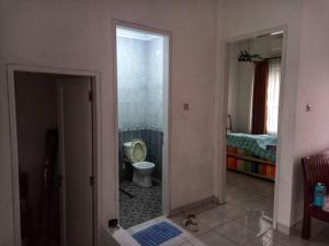 CibuntuHouse in Grand Wisata Bekasi的一间带卫生间的浴室和一间带床的房间