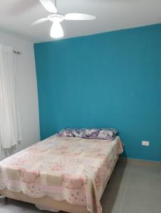 伯迪亚哥Cantinho do descanso的一间卧室设有蓝色的墙壁和一张床