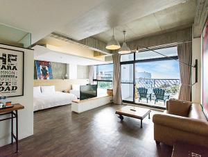鹅銮鼻垦丁泊途会馆的酒店客房配有床、沙发和电视。