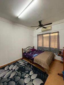 瓜拉丁加奴Family's Homestay的一间卧室配有一张床和吊扇
