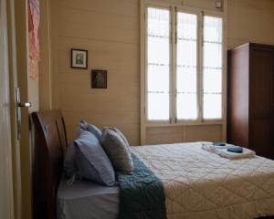 武吉丁宜Rumah Nizar (next to Ngarai Sianok)的一间卧室设有一张床和两个窗户。