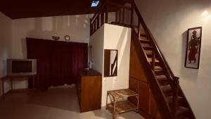 马迪凯里Coorg Sai Estate Ecobreeze Homestay的一间带楼梯和电视的客厅