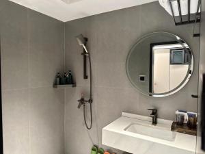 长沙沐沐酒店(长沙五一广场地铁站店)的带淋浴、盥洗盆和镜子的浴室