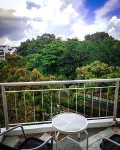 珍南海滩Langkawi Lagoon Resort Seaview的阳台配有桌椅和树木。