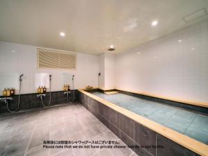 东京Hotel Plus Hostel TOKYO ASAKUSA 1的健身房中的一个空游泳池