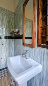 LushotoGalapagos Homestay的浴室设有白色水槽和镜子