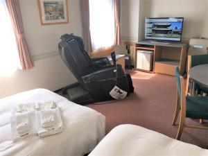 高冈市Hotel Alpha-One Takaoka的酒店客房设有两张床和电视。