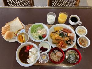 高冈市Hotel Alpha-One Takaoka的餐桌,盘子上放着食物和碗