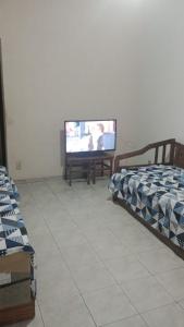 阿帕雷西达Apartamento na rua do Santuário的客厅配有两张床和一台平面电视