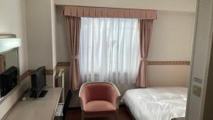 SabaeHotel Alpha-One Sabae的酒店的客房 - 带一张床、椅子和窗户