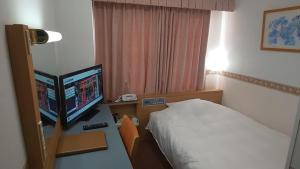 敦贺市Hotel Alpha-One Tsuruga的酒店客房设有床和电脑显示器