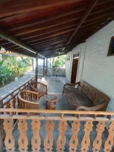 巴图卡拉Villa Embun Batukaras的阳台的门廊配有椅子和沙发