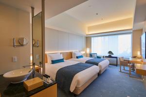 东京THE KITANO HOTEL TOKYO的酒店客房设有两张床和盥洗盆