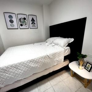 卡塔赫纳Apartamentos San José的卧室配有一张白色的大床和一张桌子