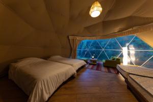 出云市glampark Shikisou Shimane的一间卧室设有两张床和大窗户