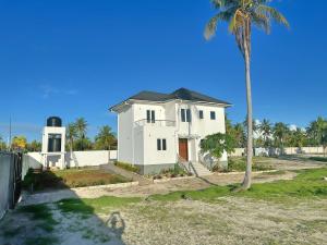 平圭Tropical Gem: 3-BR Beach Villa的前面有棕榈树的白色房子