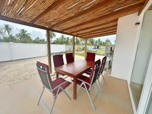 平圭Tropical Gem: 3-BR Beach Villa的天井上的木桌和椅子