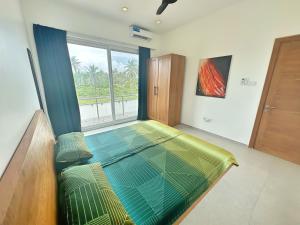 平圭Tropical Gem: 3-BR Beach Villa的窗户客房内的一张大床