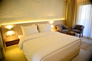 沙姆沙伊赫Reef Oasis Beach Aqua Park Resort的酒店客房,配有白色的床和椅子