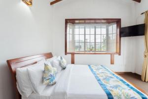 努沃勒埃利耶Aaradhya Nuwara Eliya的一间卧室设有一张床和一个窗口