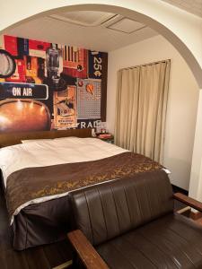神户拉拉度假村（仅限成人入住）的一间卧室配有一张带皮革长凳的床