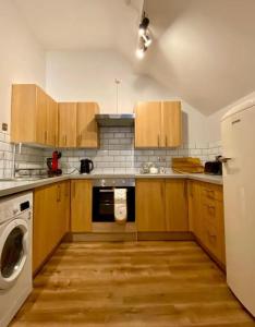 克鲁Central Crewe - Modern 1BR Haven的厨房配有木制橱柜、洗衣机和烘干机